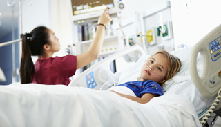 A clinician reviews the progress of a hospitalized pediatric patient A clinician reviews the progress of a hospitalized pediatric patient